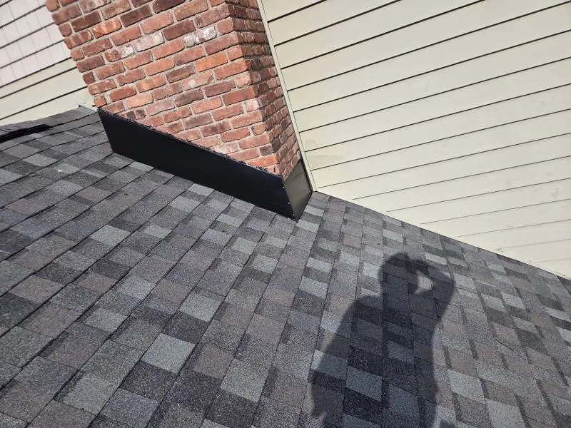 Black chimney flashing on gray shingles