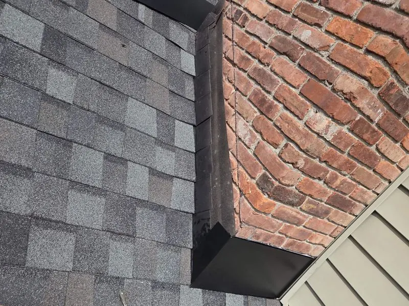 Black flashing and new shingles at chimney