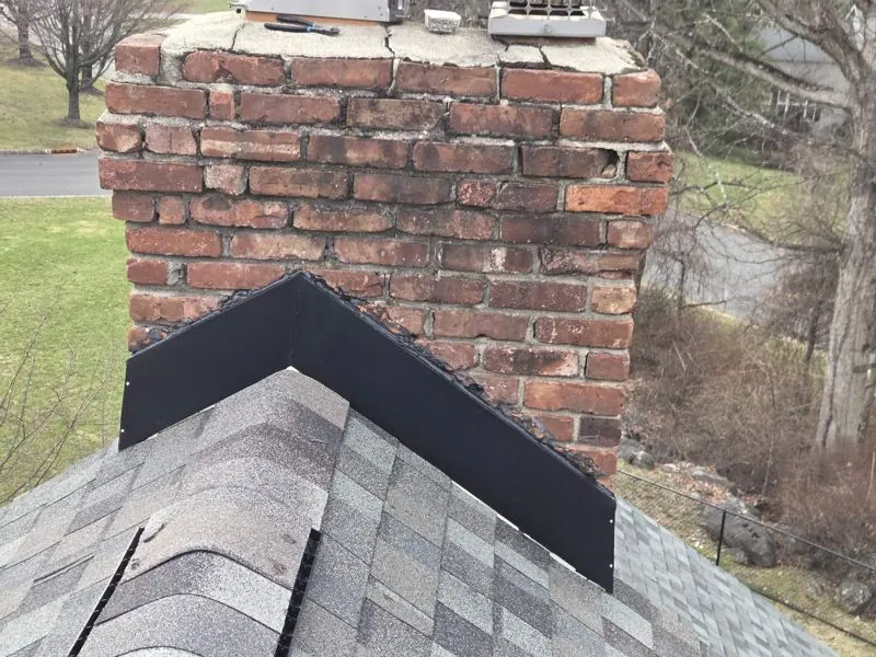 Black flashing on top of brick chimney