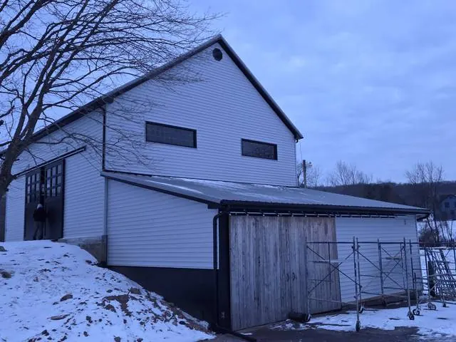 Black gutters and downspouts on white siding