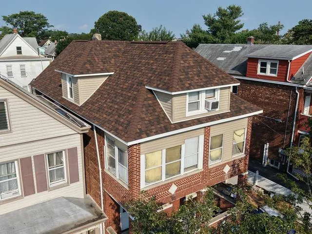 Brown shingle roof on a brick home