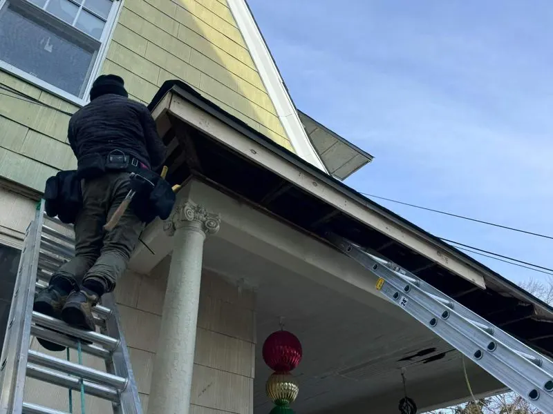 Installer on ladder at porch soffit