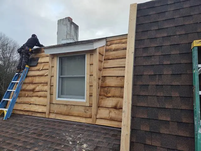 Rough-sawn wood siding and new roofing on a dormer
