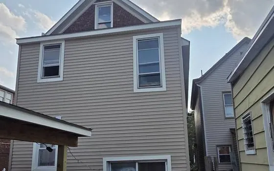 Tan vinyl siding with new trim
