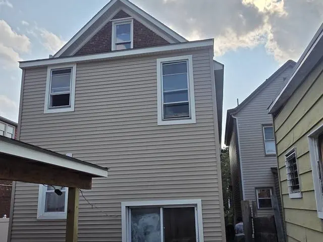 Tan vinyl siding with new window trim
